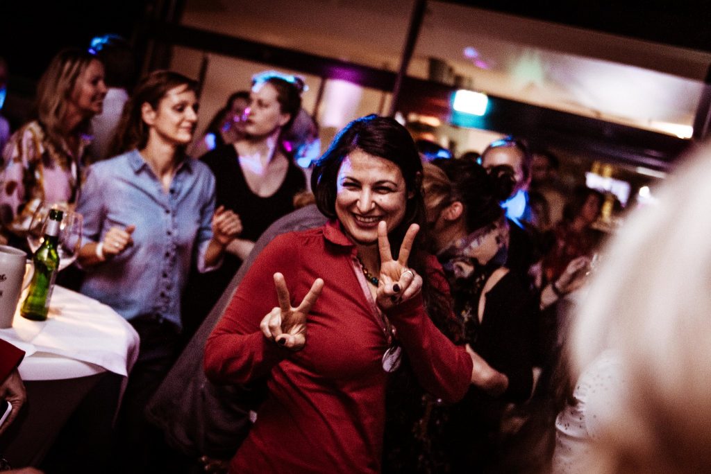 Gut gelaunte Hochzeitsgäste tanzen und zeigen Peace-Zeichen bei der Feier mit DJ eMPi in Nürnberg