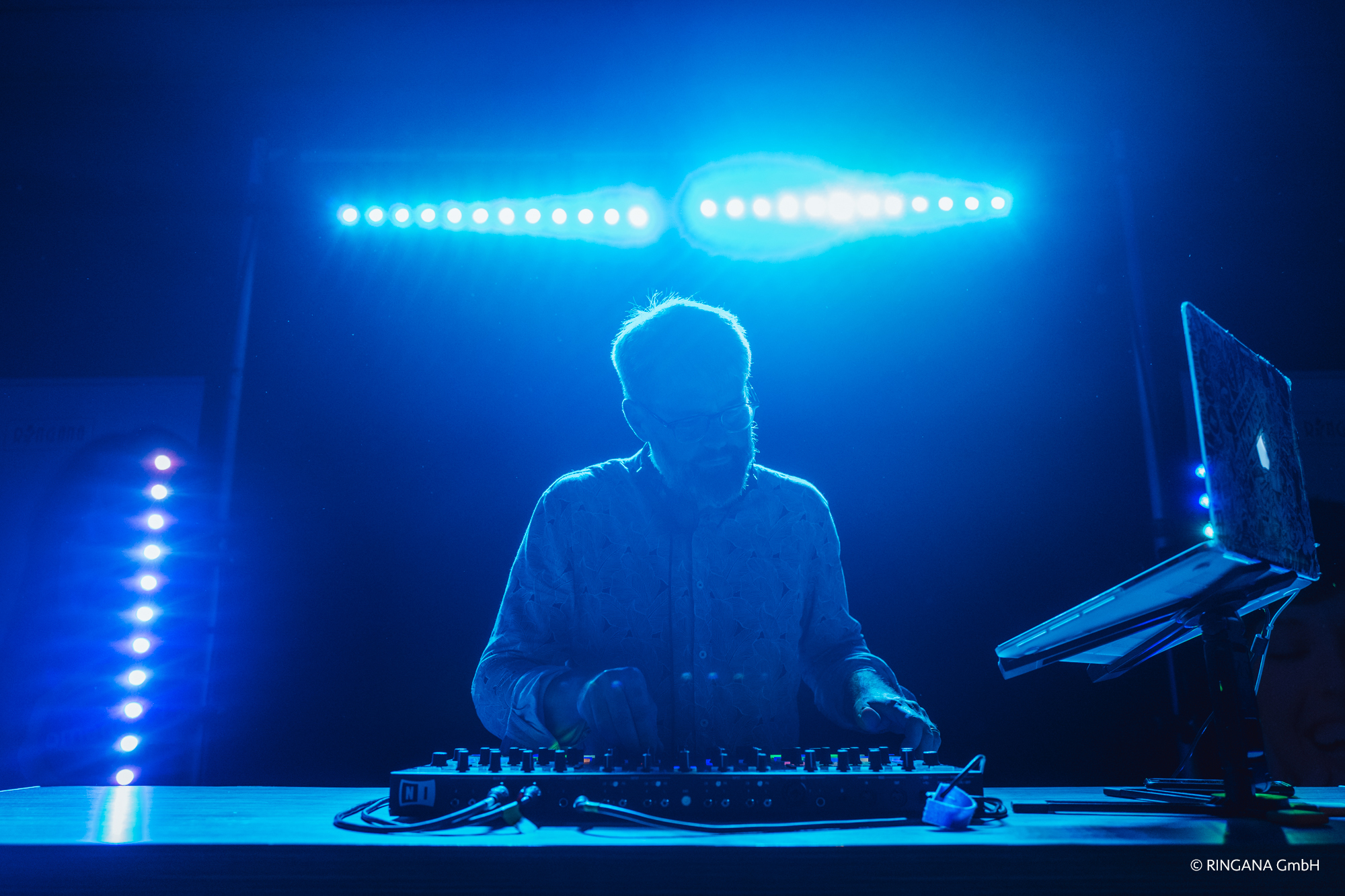 DJ eMPi im blauen LED-Licht bei einer Hochzeit in Nürnberg; abstraktes Stimmungsfoto mit DJ-Pult.